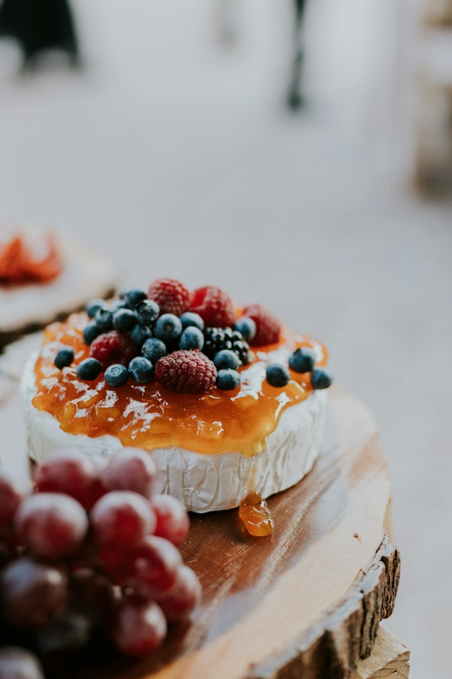 A cheese and fruit platter on a wooden board